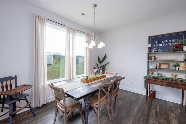 dining space with dark wood-type flooring and a chandelier