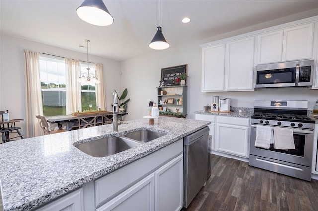 kitchen featuring appliances with stainless steel finishes, sink, white cabinets, dark hardwood / wood-style flooring, and light stone counters