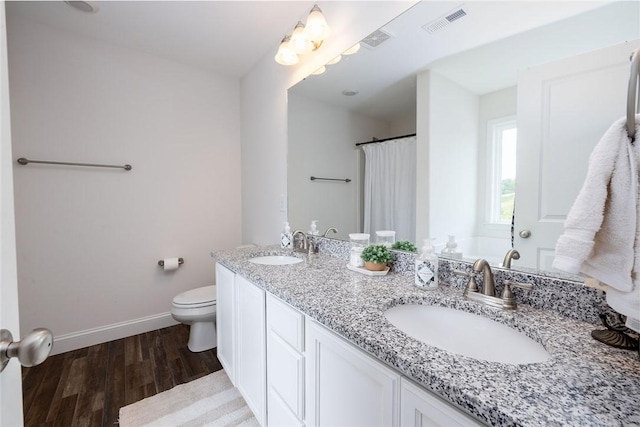 bathroom with hardwood / wood-style flooring, vanity, and toilet