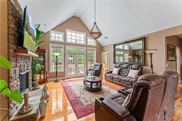 516 Serria Way, Seneca, SC 29678 - living area featuring a stone fireplace, light wood finished floors, high vaulted ceiling, and french doors