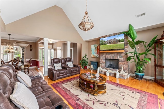 516 Serria Way, Seneca, SC 29678 - living room featuring decorative columns, a stone fireplace, high vaulted ceiling, wood finished floors, and a chandelier