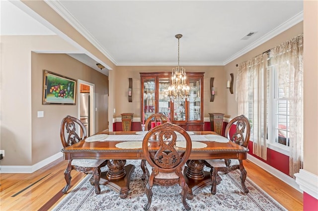 516 Serria Way, Seneca, SC 29678 - dining area with light wood finished floors, a chandelier, baseboards, and crown molding
