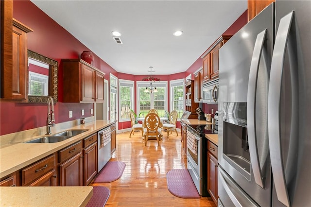 516 Serria Way, Seneca, SC 29678 - kitchen with stainless steel appliances, a sink, a chandelier, light countertops, and light wood-type flooring