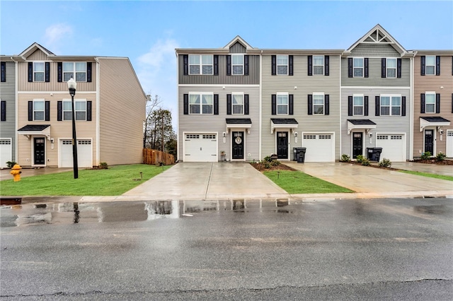 townhome / multi-family property featuring a garage and a front lawn