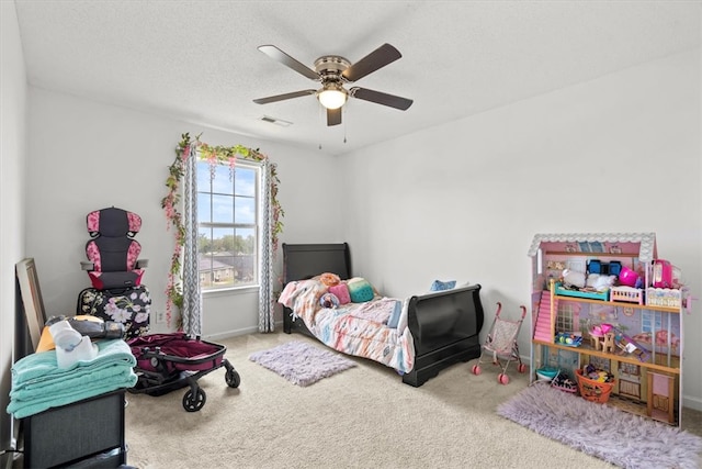 carpeted bedroom with ceiling fan and a textured ceiling