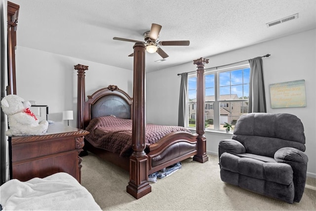 carpeted bedroom featuring ceiling fan and a textured ceiling