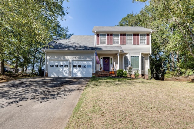 colonial inspired home with a front yard, a garage, and a porch