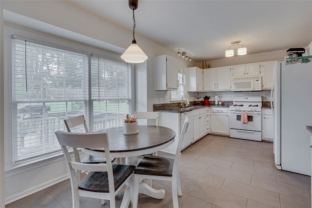 kitchen with sink, white cabinetry, hanging light fixtures, decorative backsplash, and white appliances