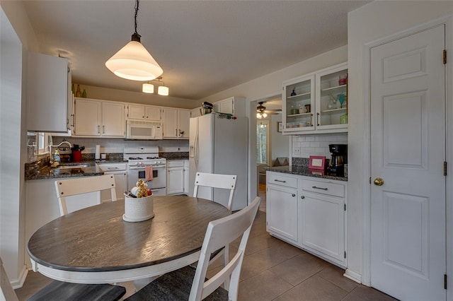 tiled dining room featuring sink and ceiling fan