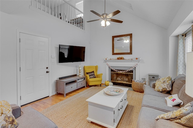 living room featuring high vaulted ceiling, light wood-type flooring, and ceiling fan