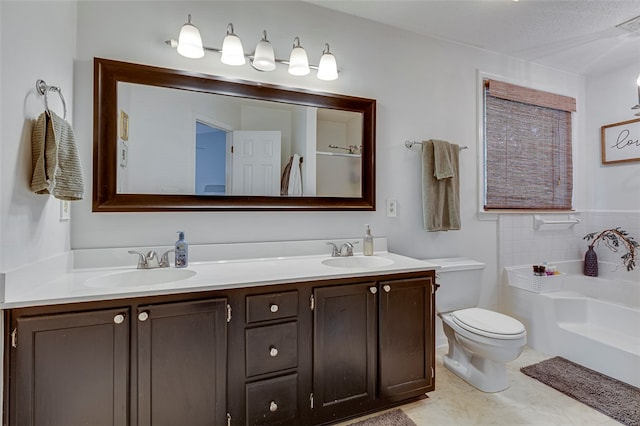 bathroom with a tub to relax in, vanity, a textured ceiling, toilet, and tile patterned floors