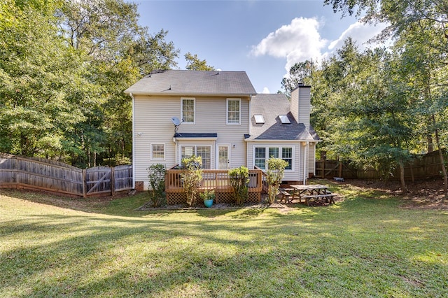 back of property with a wooden deck and a yard