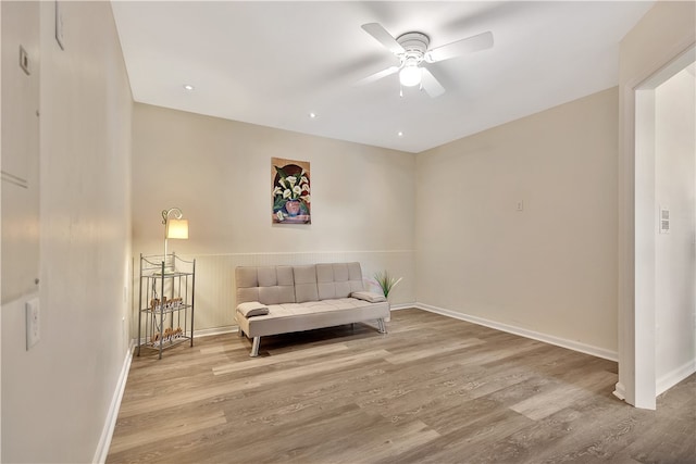 living area featuring hardwood / wood-style floors and ceiling fan