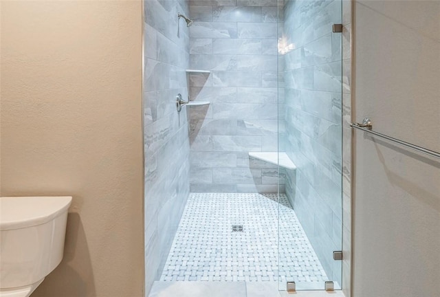 bathroom with an enclosed shower and toilet