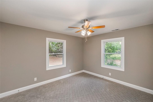 spare room with carpet floors, a wealth of natural light, and ceiling fan