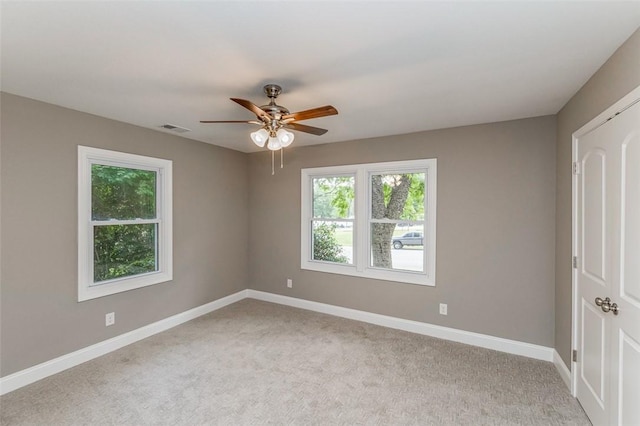 carpeted spare room featuring ceiling fan