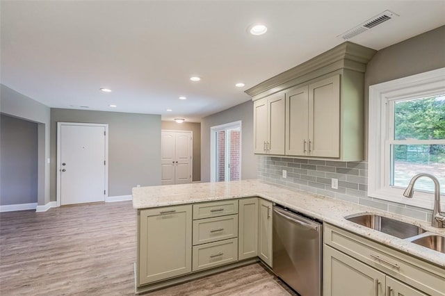 kitchen with cream cabinetry, sink, kitchen peninsula, and dishwasher