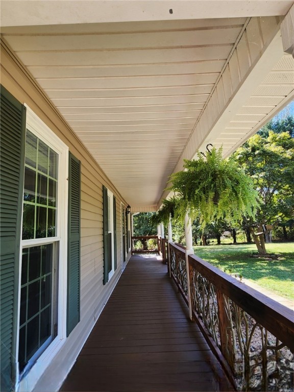 deck with a porch and a lawn