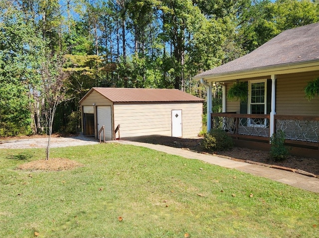 view of home's exterior featuring a garage, a porch, a yard, and an outbuilding