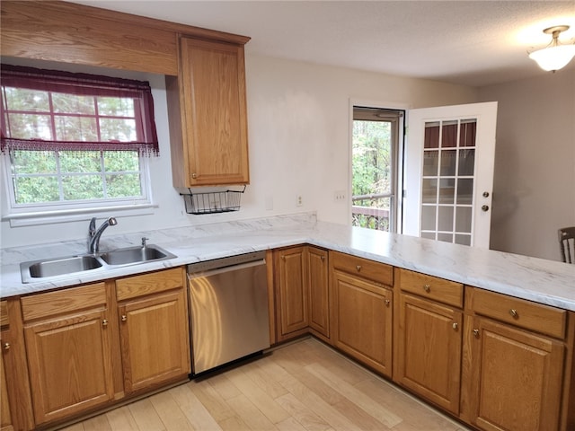 kitchen with light hardwood / wood-style flooring, dishwasher, kitchen peninsula, and sink