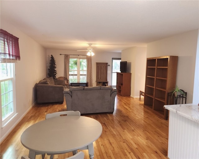 living room with ceiling fan and light hardwood / wood-style flooring