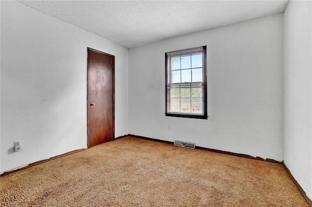 carpeted spare room featuring a textured ceiling