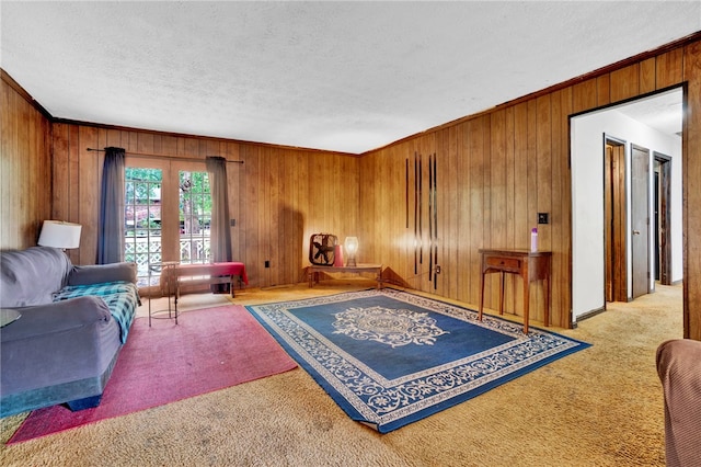 living room featuring ornamental molding, wood walls, and a textured ceiling