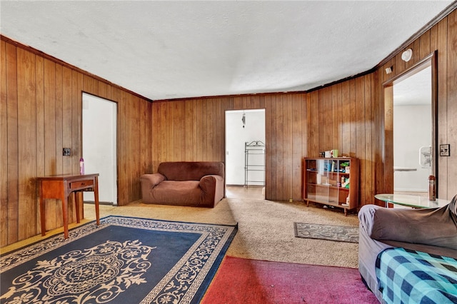 living room with light carpet, a textured ceiling, wood walls, and crown molding