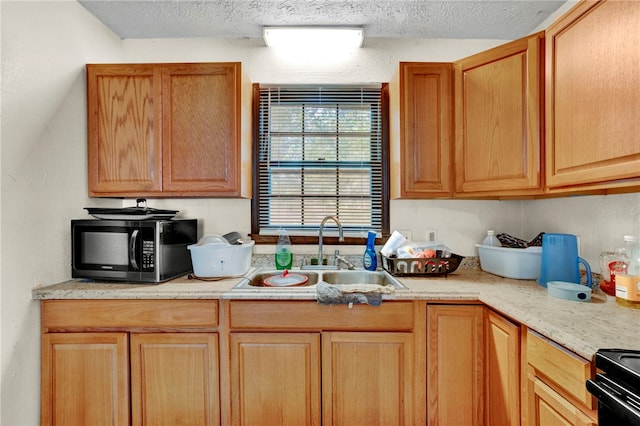 kitchen with electric range, sink, and a textured ceiling