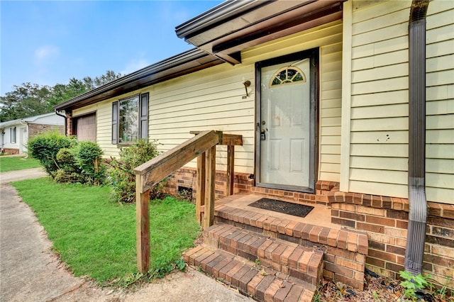 property entrance featuring a lawn