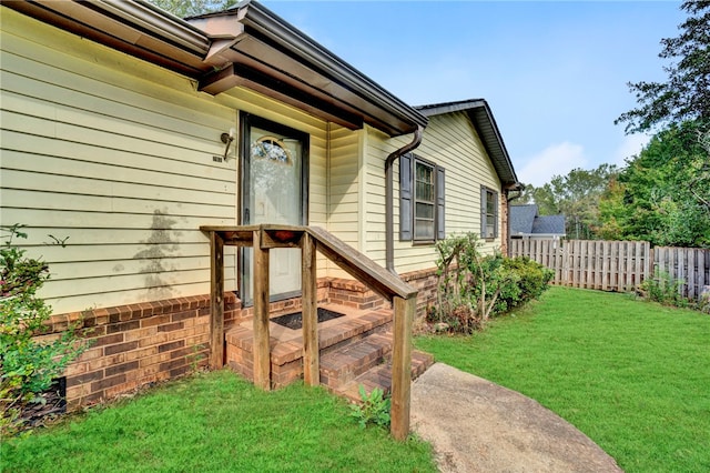 property entrance featuring a lawn