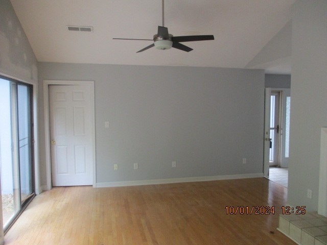 spare room featuring vaulted ceiling, light hardwood / wood-style flooring, and ceiling fan