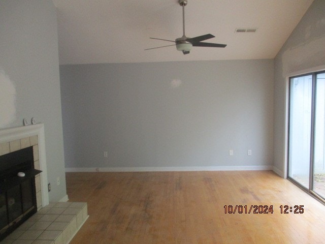 unfurnished living room featuring ceiling fan, light hardwood / wood-style flooring, vaulted ceiling, and a wealth of natural light