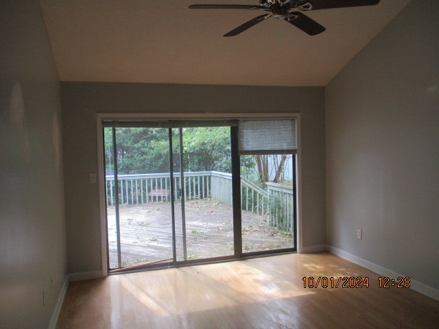 unfurnished room featuring hardwood / wood-style flooring, ceiling fan, and vaulted ceiling