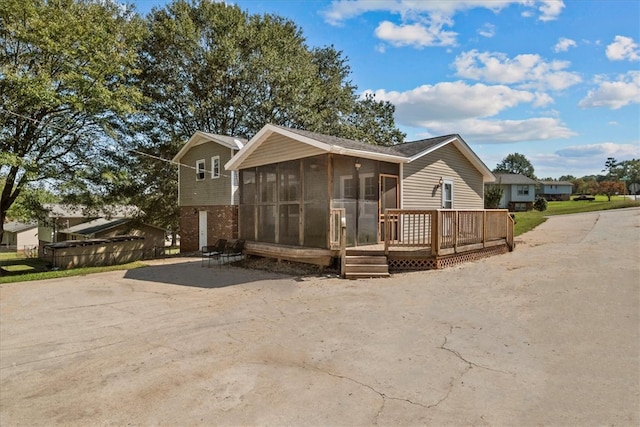 view of front of home with a sunroom and a wooden deck