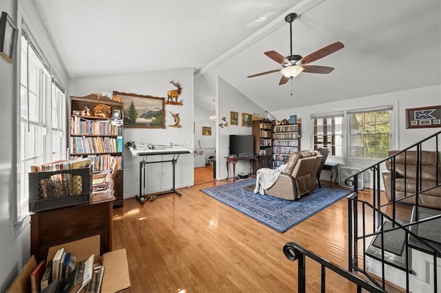 living room with lofted ceiling with beams, ceiling fan, and hardwood / wood-style floors