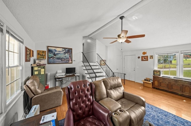 living room featuring lofted ceiling, ceiling fan, hardwood / wood-style floors, and a textured ceiling