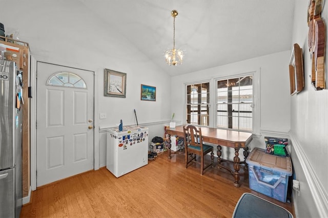 dining room featuring a chandelier, vaulted ceiling, and light hardwood / wood-style floors