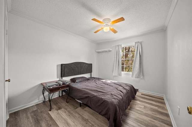 bedroom featuring ornamental molding, hardwood / wood-style flooring, a textured ceiling, and ceiling fan