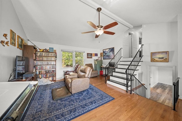 living room with ceiling fan, lofted ceiling with beams, and hardwood / wood-style flooring