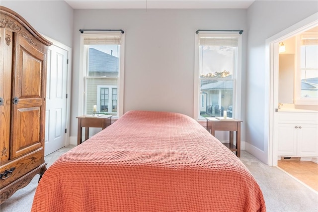 carpeted bedroom featuring ensuite bath