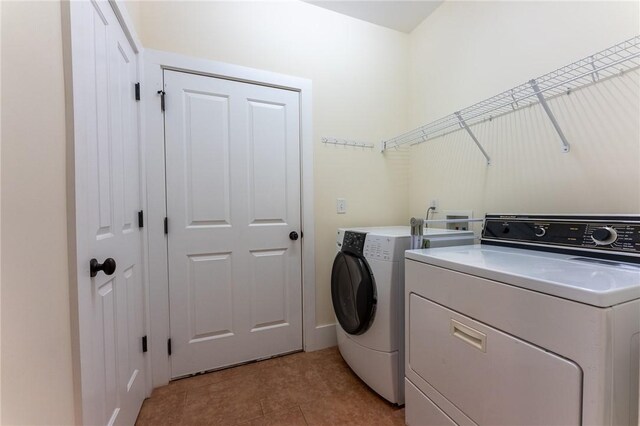 clothes washing area with light tile patterned floors and independent washer and dryer