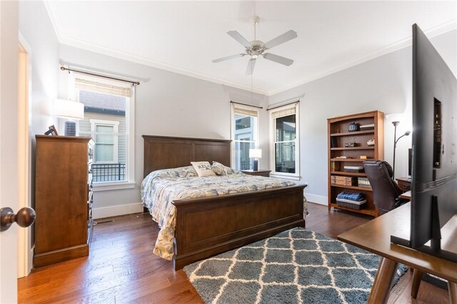 bedroom featuring crown molding, ceiling fan, dark hardwood / wood-style flooring, and multiple windows