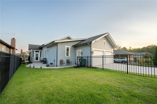 back house at dusk with a garage, a yard, and cooling unit