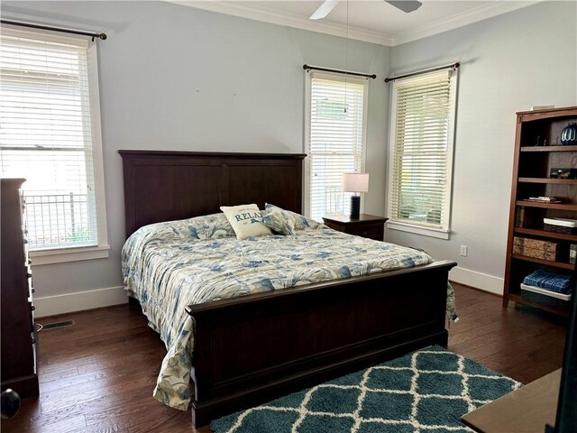 bedroom with dark hardwood / wood-style flooring, ornamental molding, and ceiling fan