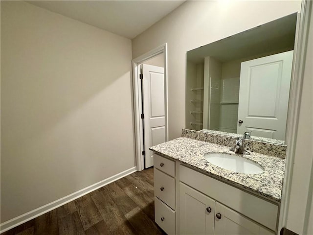 bathroom with hardwood / wood-style flooring, vanity, and a shower with door