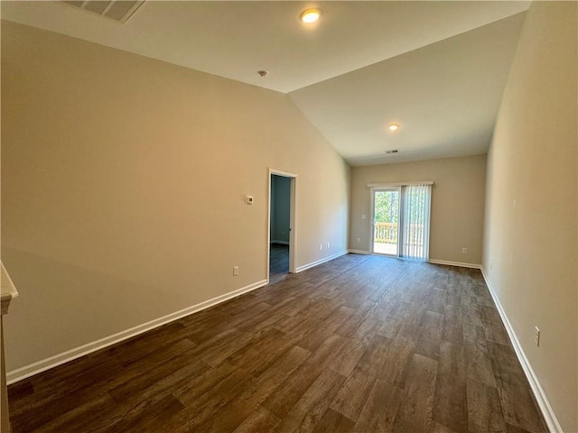 empty room featuring dark wood-type flooring and vaulted ceiling