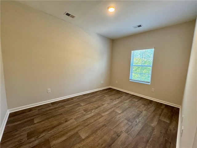 spare room featuring dark wood-type flooring