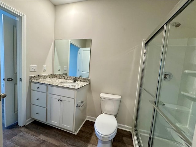 bathroom featuring vanity, wood-type flooring, an enclosed shower, and toilet