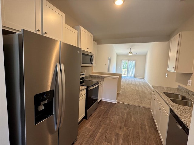 kitchen featuring light stone counters, white cabinets, and stainless steel appliances